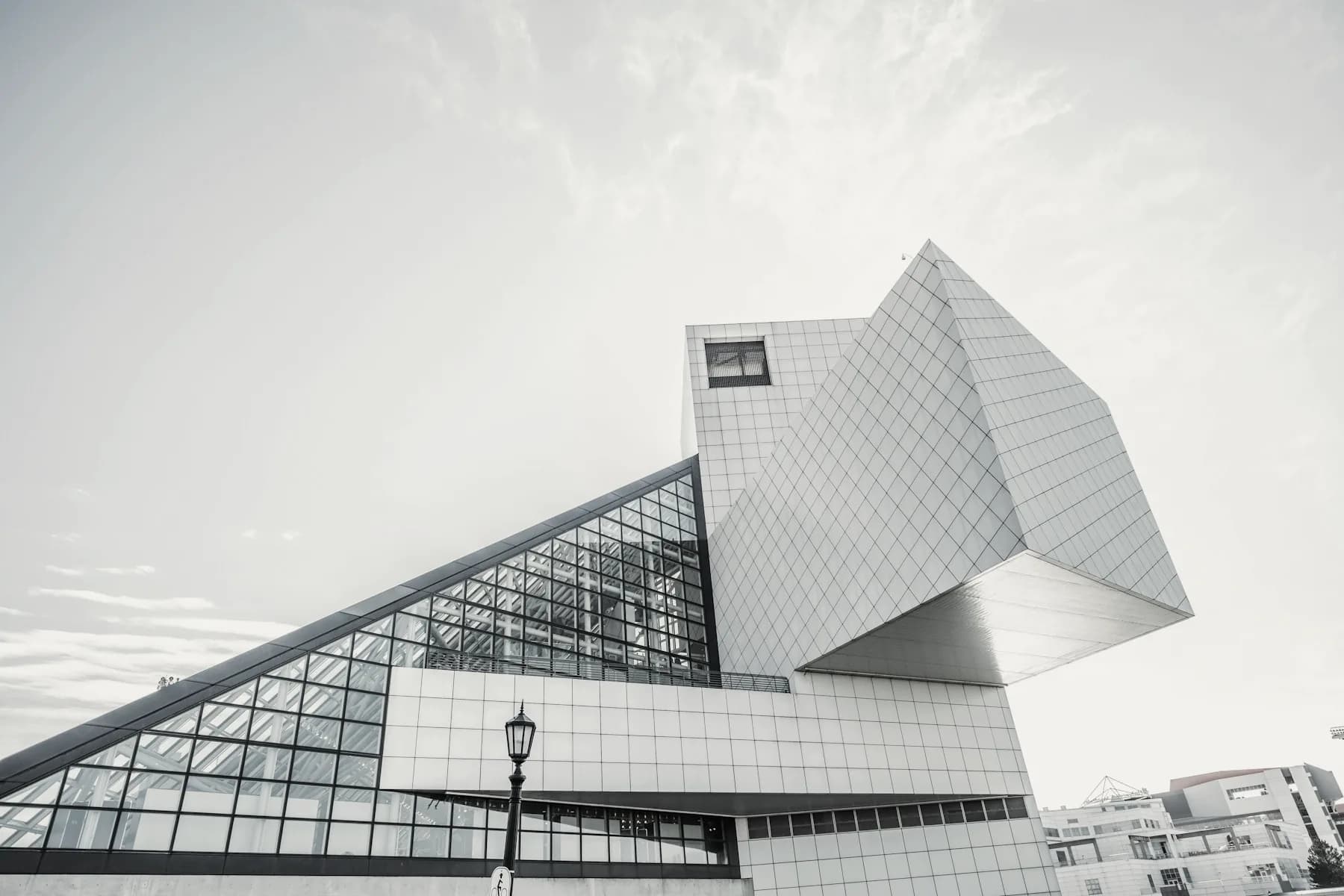 A faceted glass and steel building rising against a pale sky.