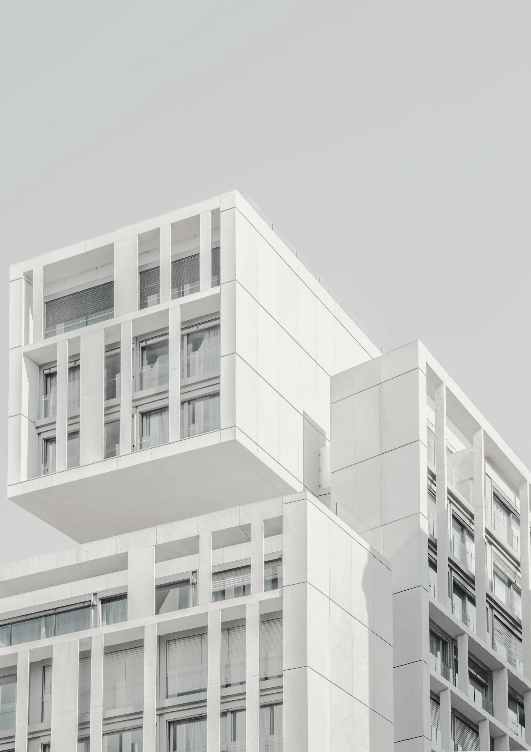 Terraced white residential volumes stacked against an open sky.
