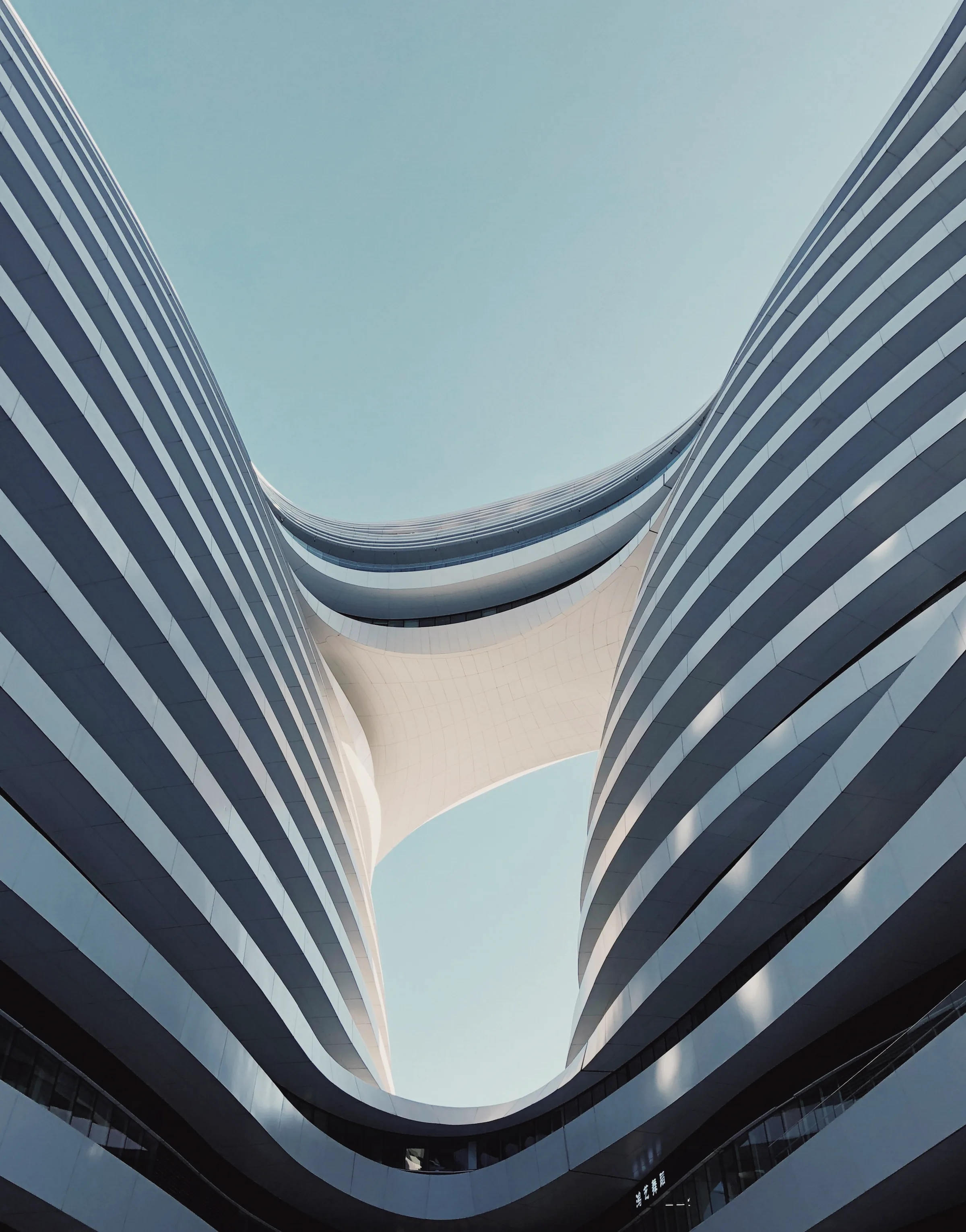 A sweeping curved pavilion roof opening to the sky.